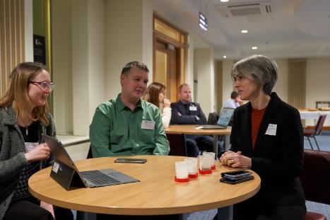 Three people sitting around a desk discussing KTP at a UKRI event in Belfast