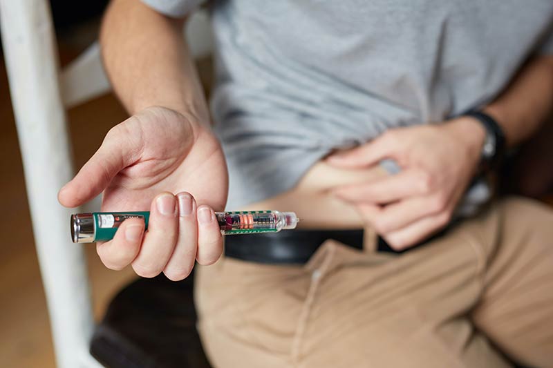 Diabetic man injecting himself