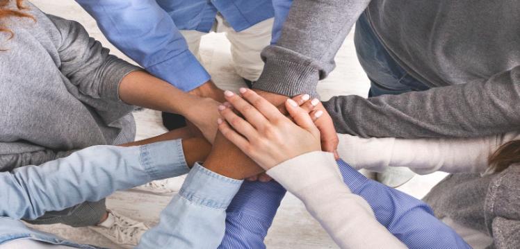 Group of people putting hands together