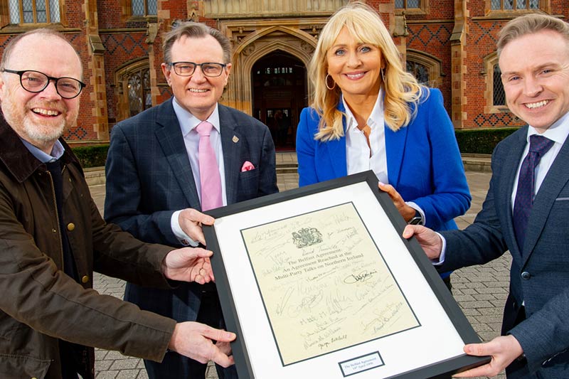 The VC and senior staff holding a framed document