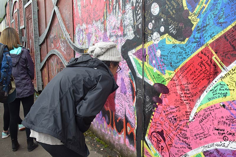 a student examining the peace wall