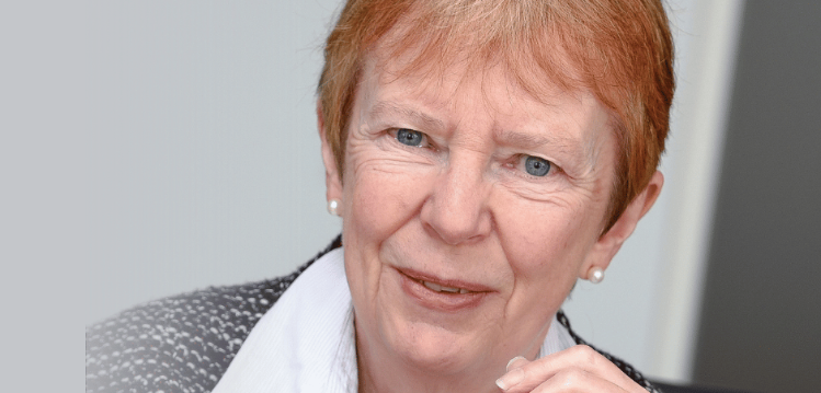 A cropped photo of Dame Kate Barker on a blue background