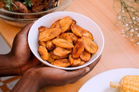 Person holding a bowl of plantain chips