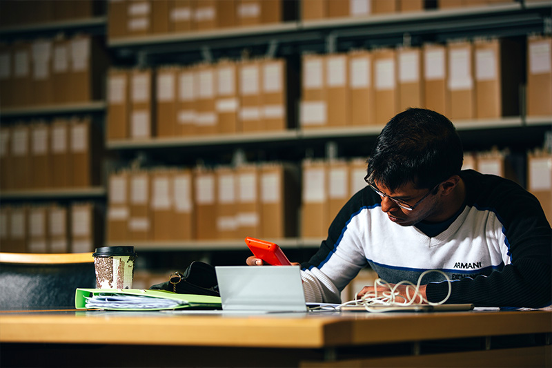 male student studying at a desk in the McClay library