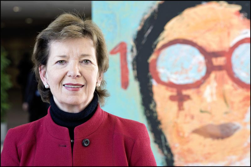 Former President of Ireland, Mary Robinson, standing in front of a colourful mural