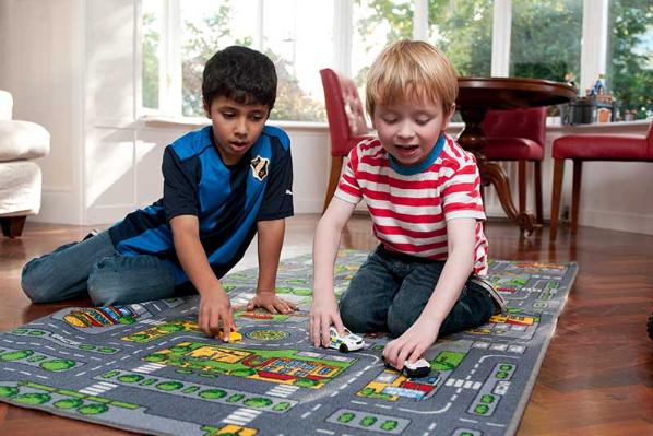 Two primary school aged boys playing with toy cars.