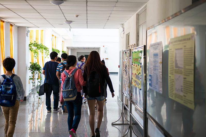 students walking through the hallway of the China Medical University – Queen’s Joint College campus