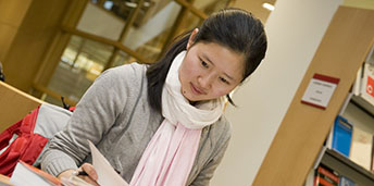 female student looking at a book