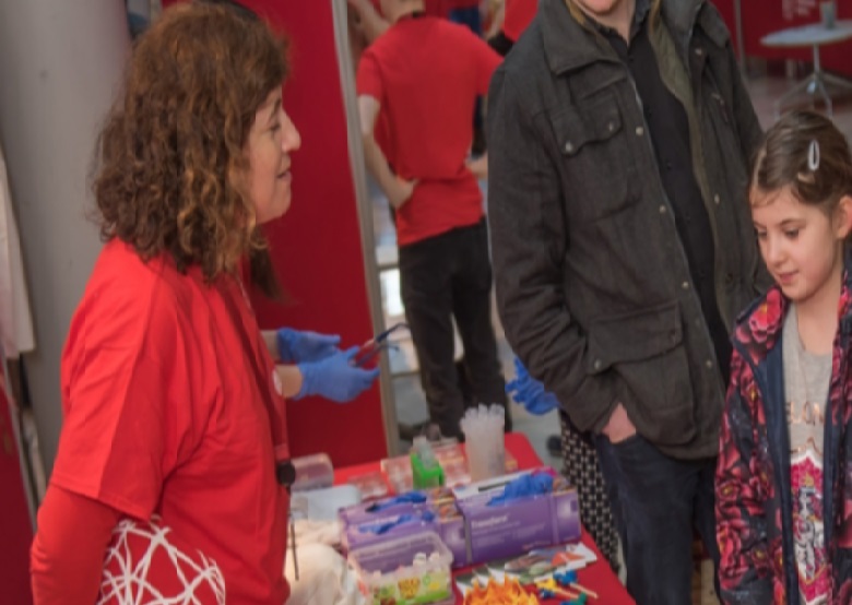 Woman talking to child at science fair 