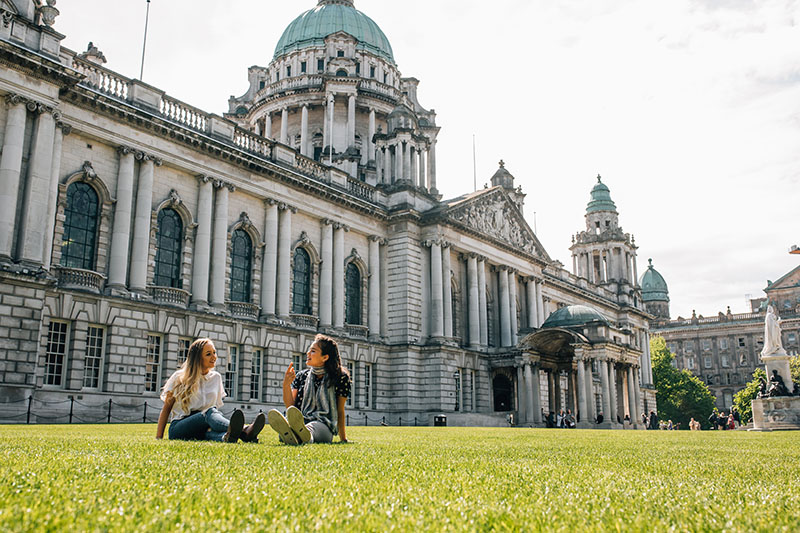 Students seated on the grass in front of City Hall