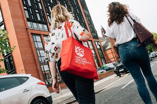 Students walking with a Queen's branded bag