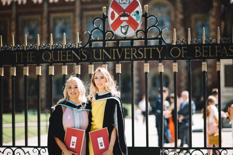 2 female graduates at the gate, summer 2019, Dan Smyth