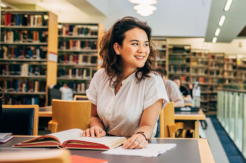 A student looking out the window of The McClay Library