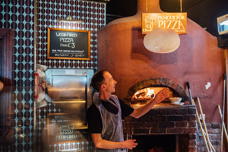 Man making pizza in The Parlour Bar