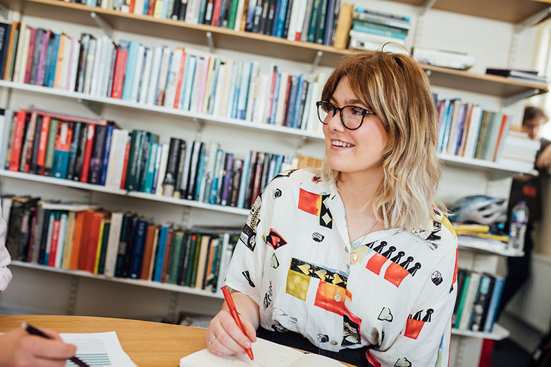 Student in front of wall of books