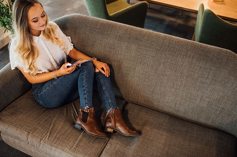 Student on her phone on the sofa