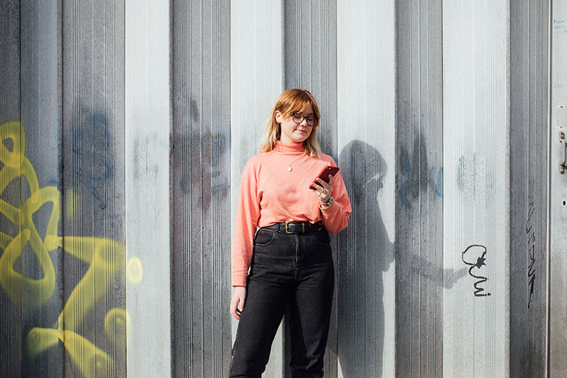 Student in a pink top on her phone