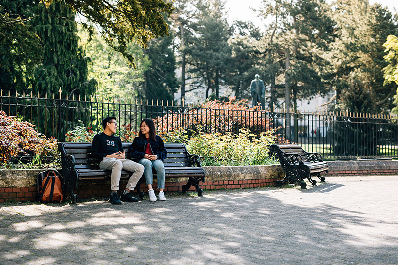 Students seated on a bench outside Botanic Gardens