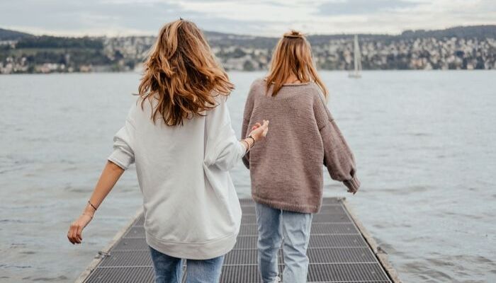 Two women walking on a pier
