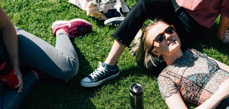 Fresher students relaxing on grass