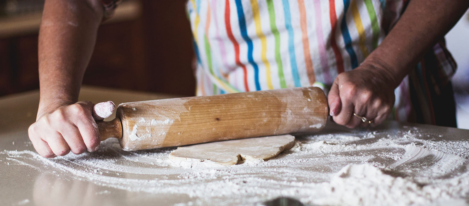 Person using a rolling pin on dough