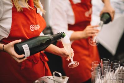 Two waiters pour champagne