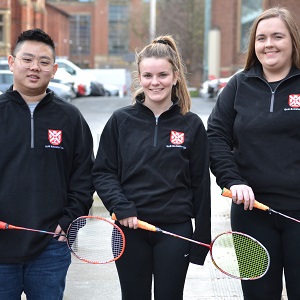 Three students hold badminton rackets