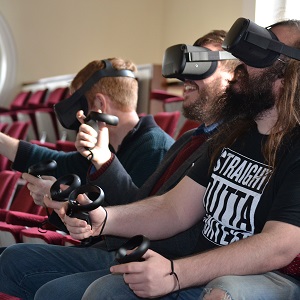 Three students interact with VR sets
