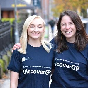 Two students from the GP society put their arms around each other and smile