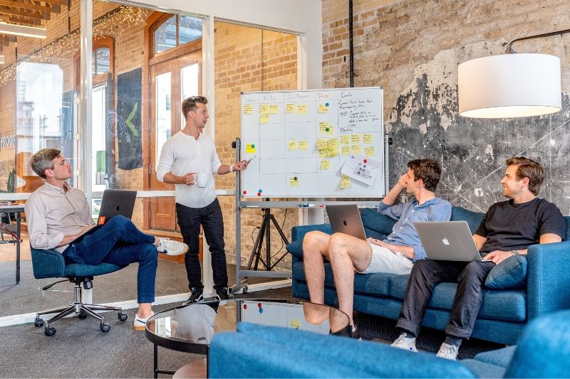 Group of young male professionals writing ideas on a white board