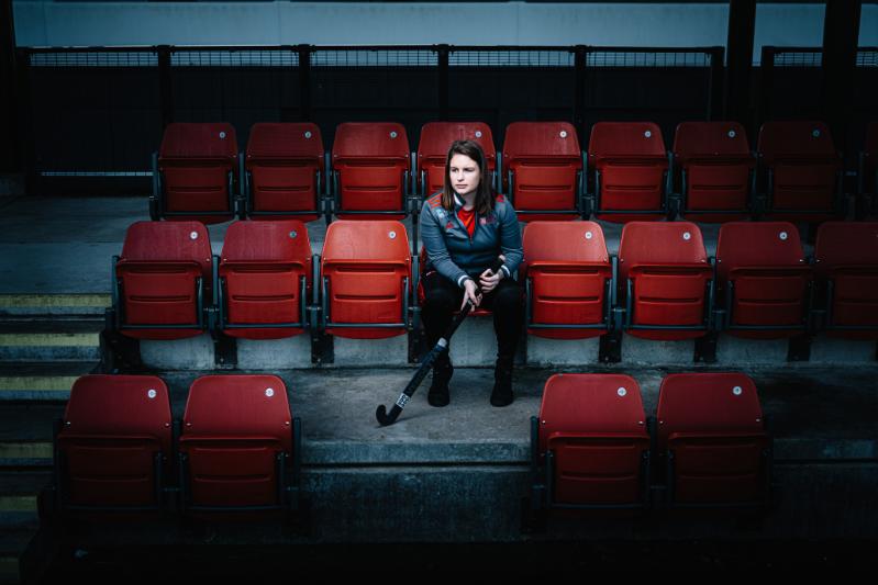 Female hockey player sitting in the stands, alone