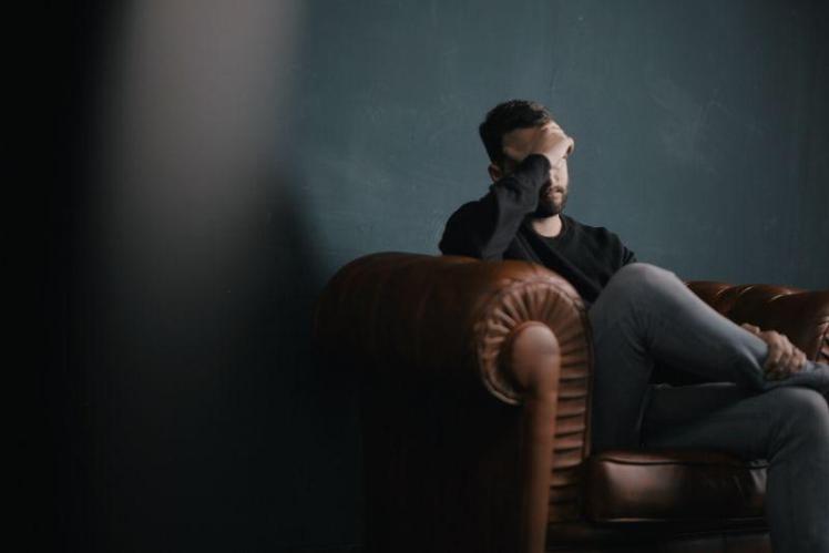 Man sits depressed on a sofa