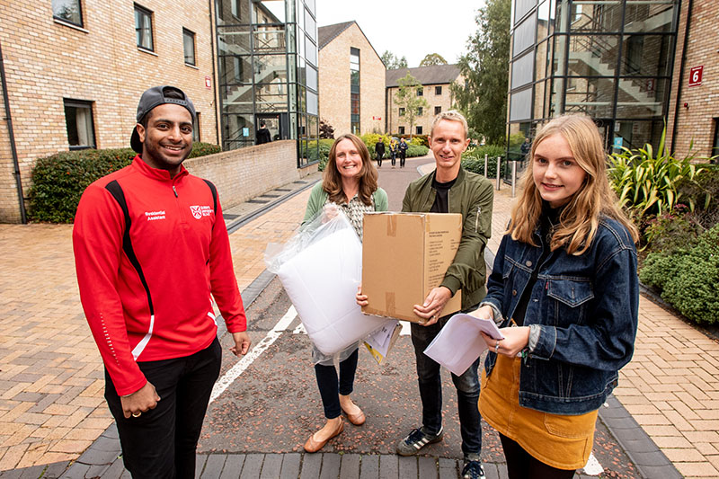 Student arrives at Queen's accommodation with parents and is greeted by happy student helper