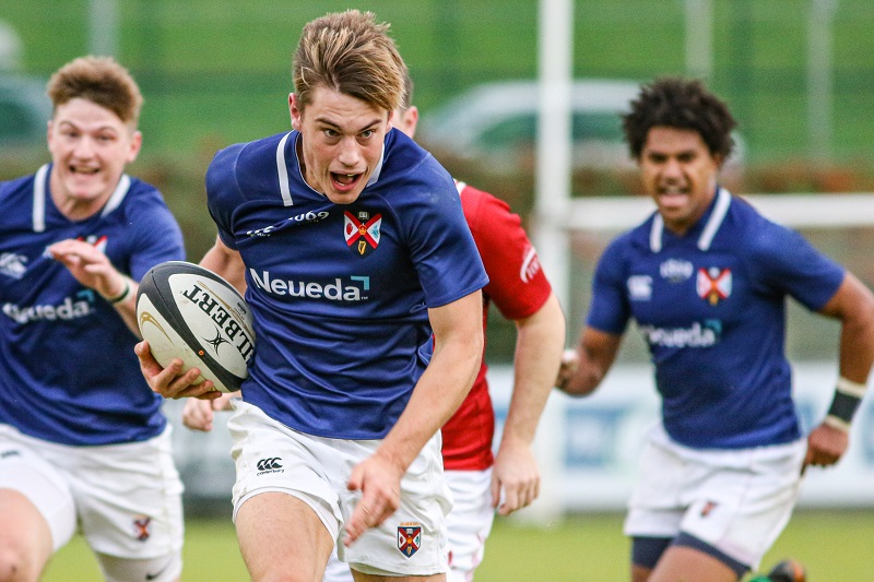 Rugby player storms forward with a rugby ball