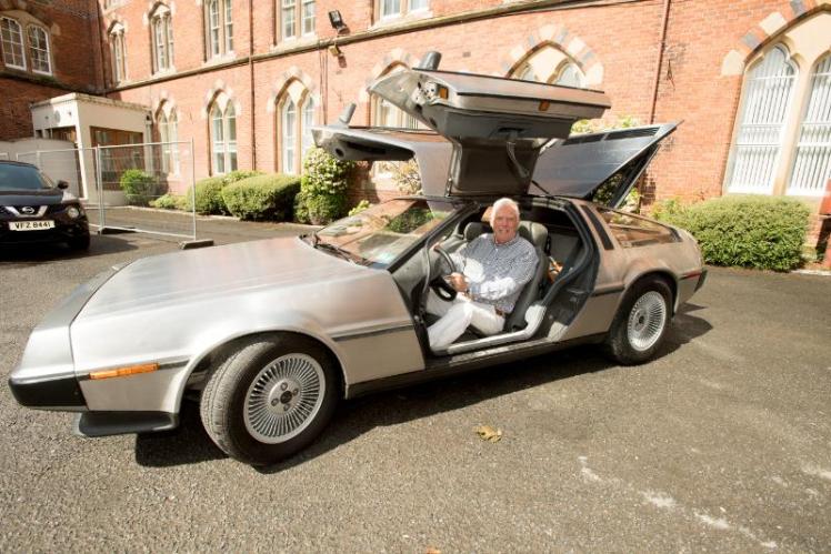 Man in drivers seat of delorean with door open