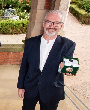 Richard English holding his medal