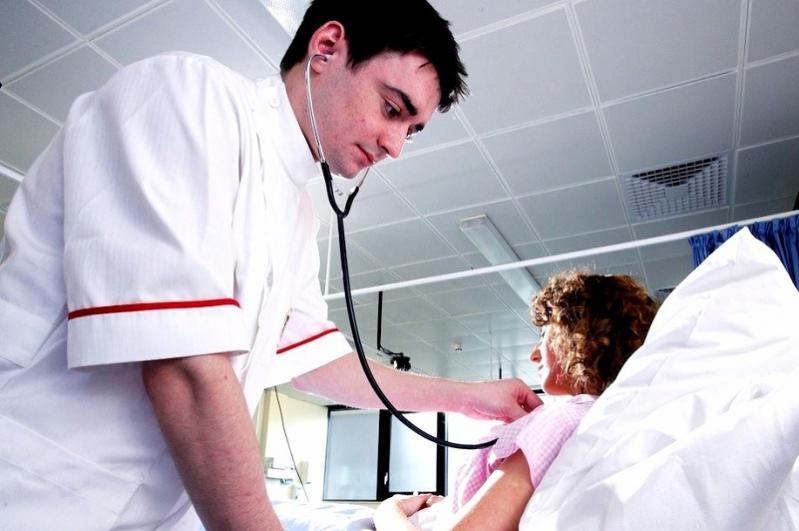 nurse using stethoscope on patient