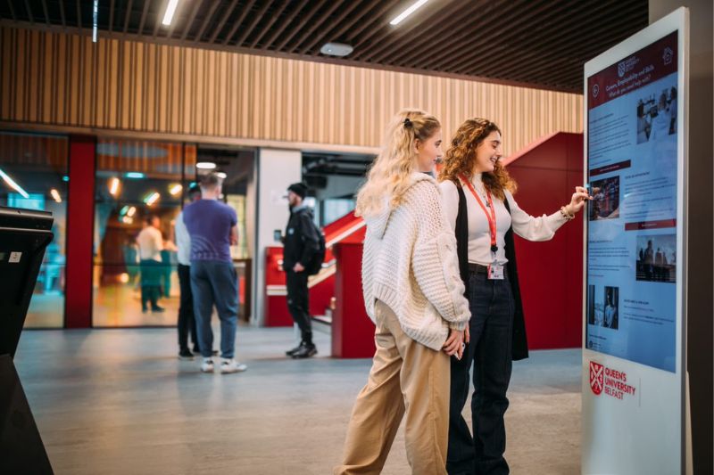 student being shown some technology by a staff member