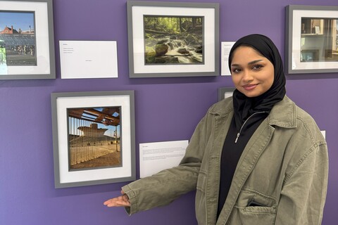 Student Afra in standing in front of her photo at the AEL image competition