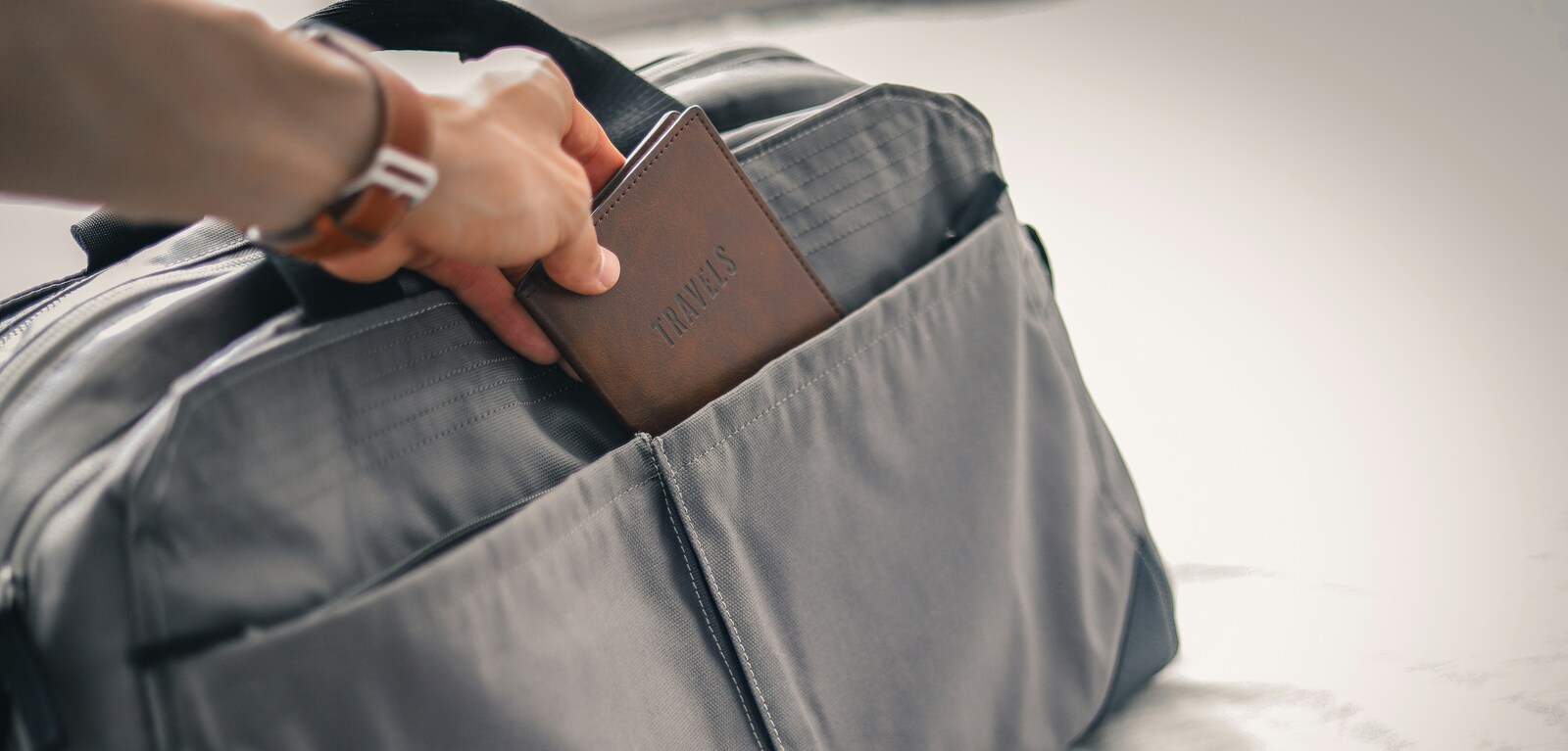 Person putting passport into bag