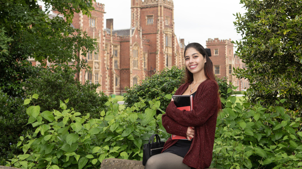 Student Brittany sits on wall in front of Lanyon building