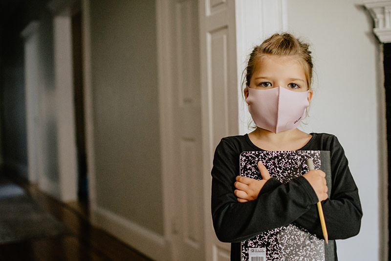 Young school child in a mask