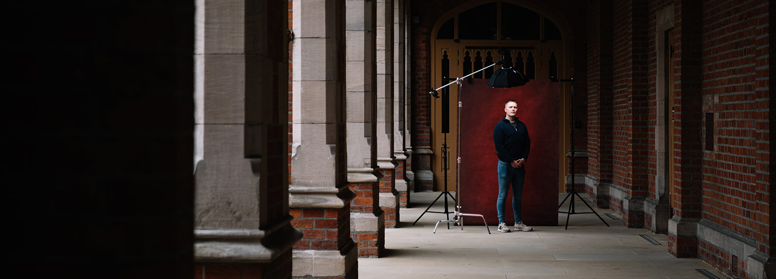 Student being photographed in the cloisters at Queen's