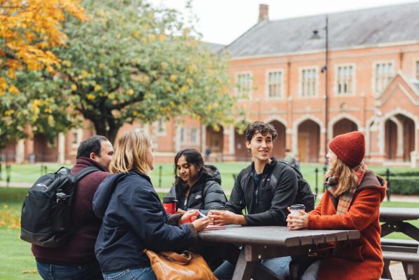 Student group having coffee at bench in the Quad