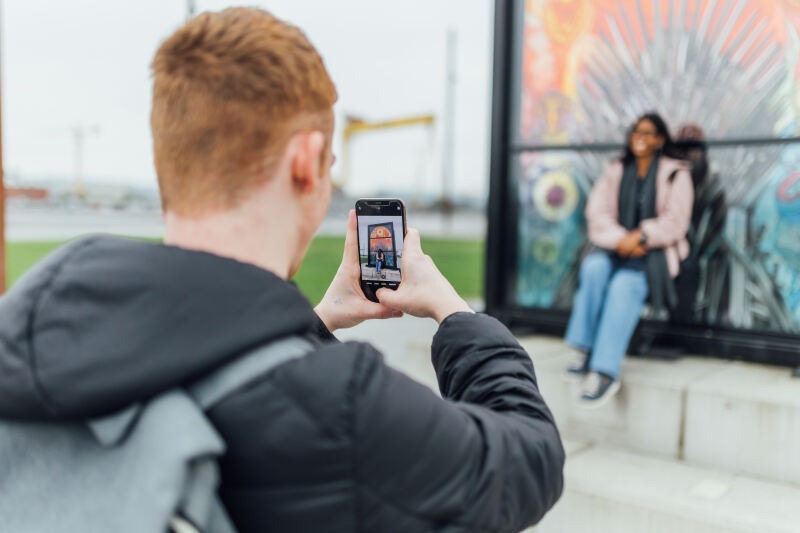 Student Conor takes photo of student Florence in front of Game of Thrones glass display