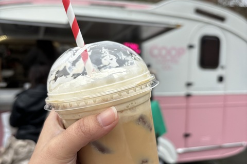 Student holding iced latte from Coop Coffee Co van