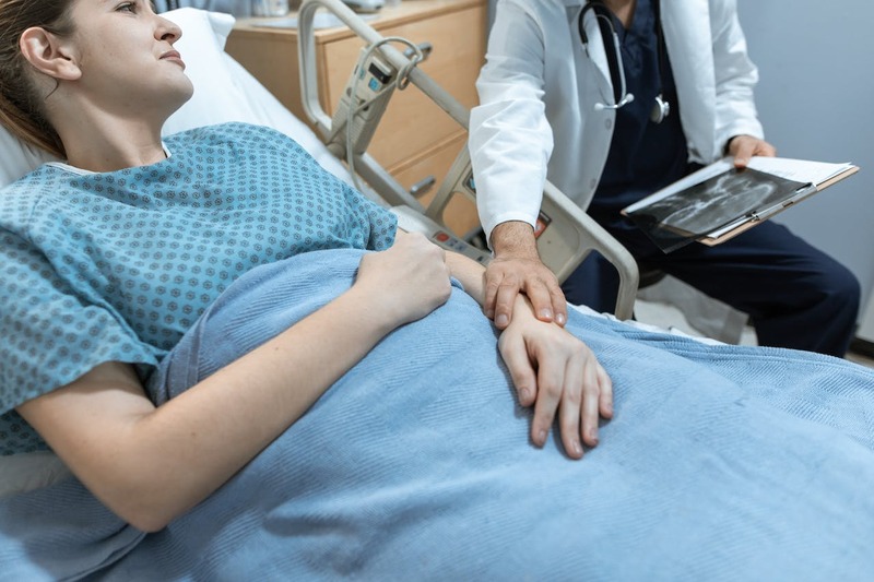 Doctor comforting patient in hospital bed