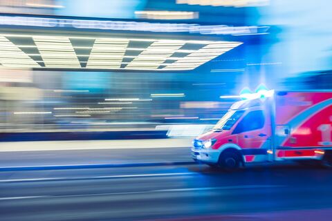 Emergency ambulance driving past hospital