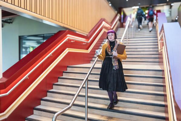 Student Emma in One Elmwood walking downstairs
