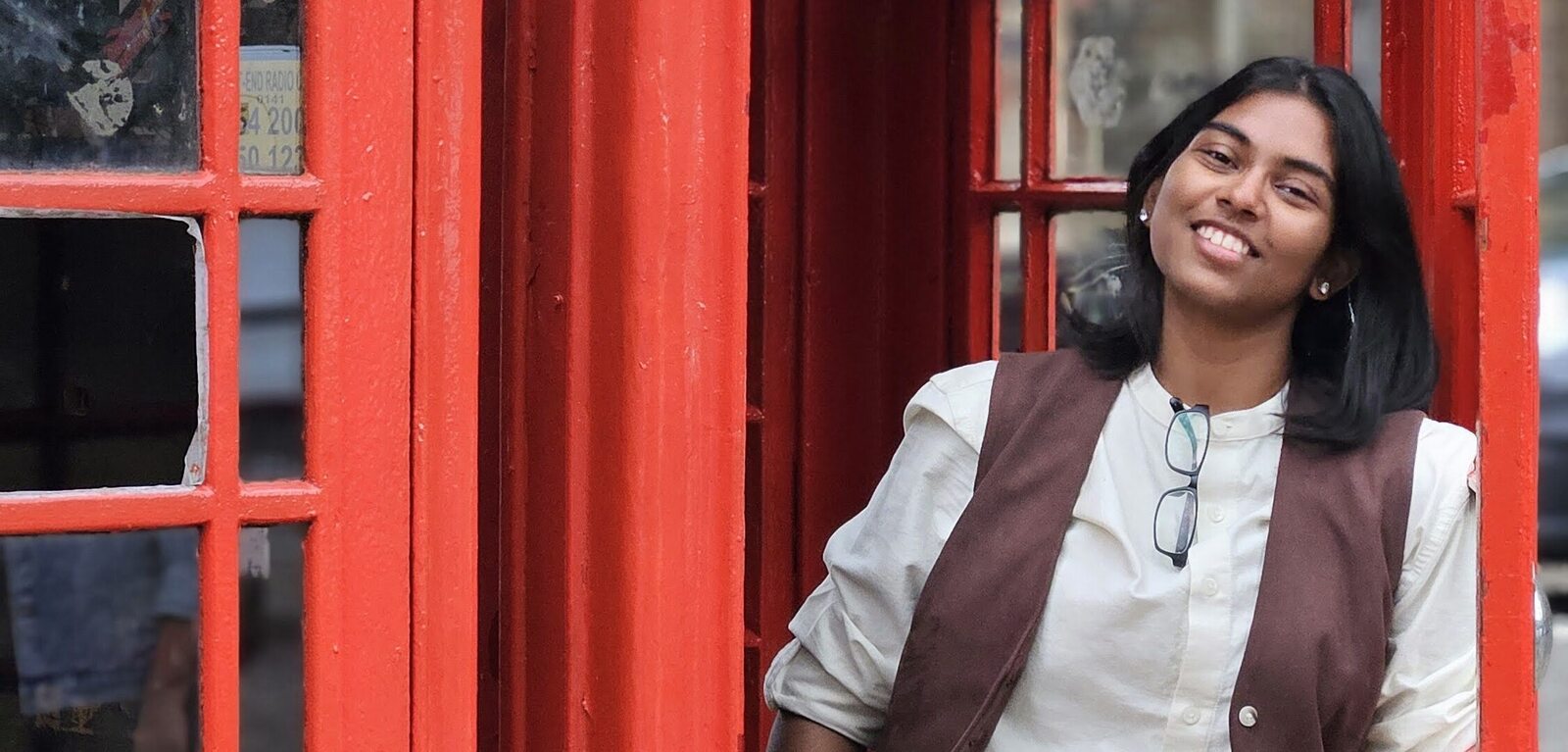 Student Florence standing beside red telephone box in Glasgow